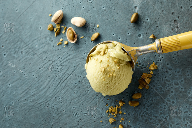 Pistachio ice cream on scoop and nuts