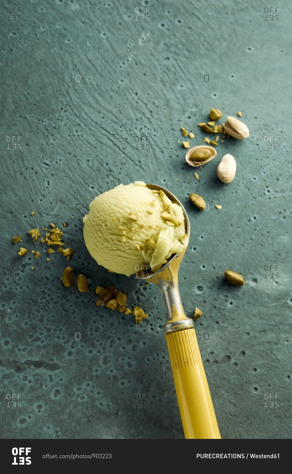 Pistachio ice cream on scoop and nuts
