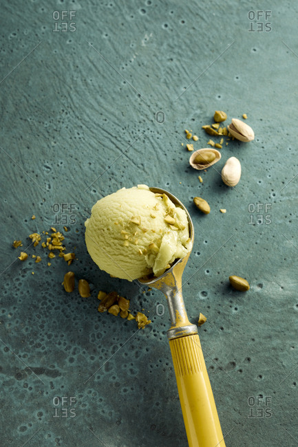 Pistachio ice cream on scoop and nuts