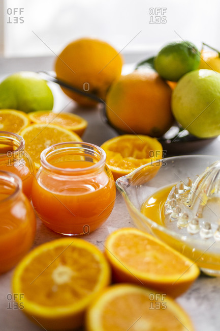 Freshly cut oranges and jars of orange juice