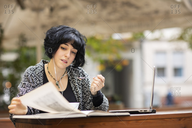 Close-up view of dancer tying up the ribbons of her toe shoe on grass