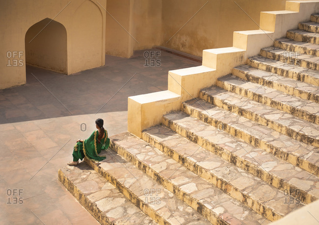 Indian woman resting on steps at the Jantar Mantar Astrological Park, Jaipur, India