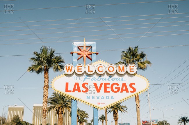 Las Vegas, Nevada, USA - December 7, 2017: Green exotic palm trees and signpost Welcome to fabulous Las Vegas Nevada on road on bright day