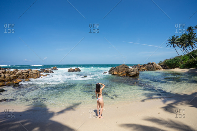 Lady in swimsuit resting on exotic lonely seashore