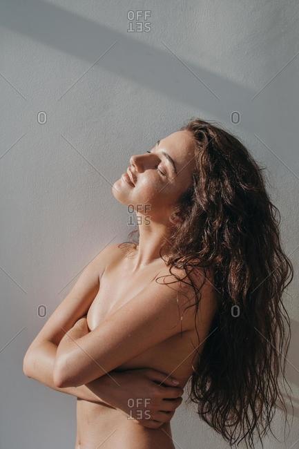 Portrait of a beautiful woman covering her breasts stock photo - OFFSET