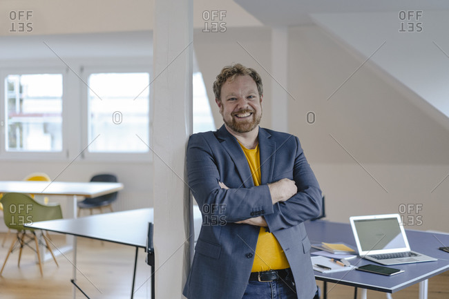Portrait of a smiling businessman in office with table tennis table