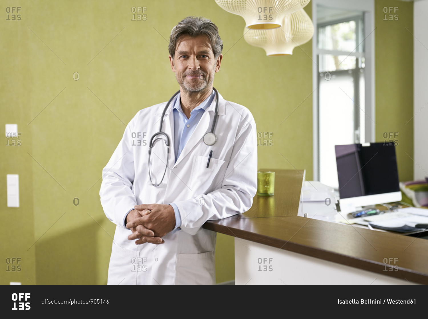 Portrait of confident doctor at reception in his medical practice