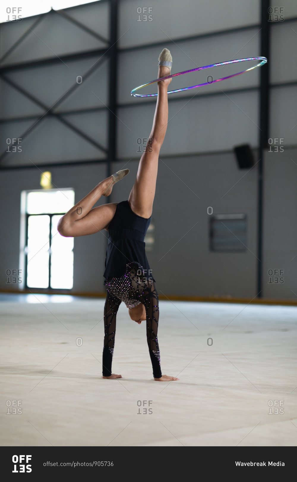 Front view of teenage mixed race female gymnast performing at the gym ...