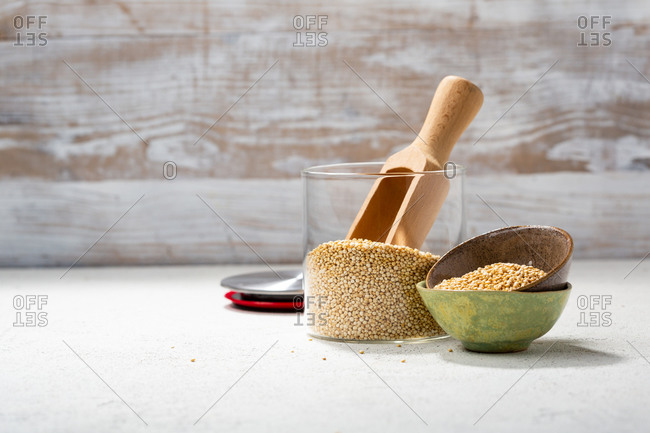 Quinoa in a glass jar and small bowls with a wooden scoop