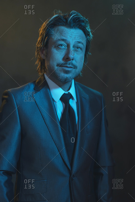 Portrait of a man dressed in a tuxedo under blue light