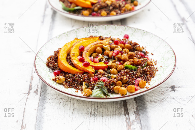 Studio shot of salad of red quinoa with baked pumpkin- chickpeas- pomegranate- basil- walnuts and pumpkin seeds