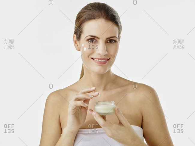 Portrait of smiling woman with cream jar