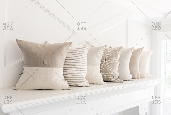 Neutral pillows on a fireplace mantle