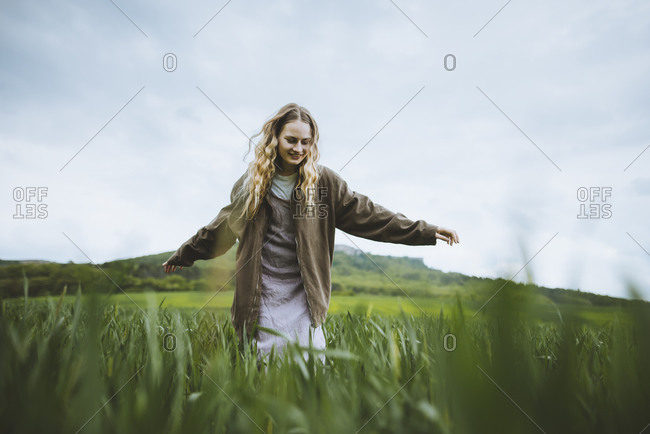 Smiling woman with her arms outstretched in field in Crimea, Ukraine