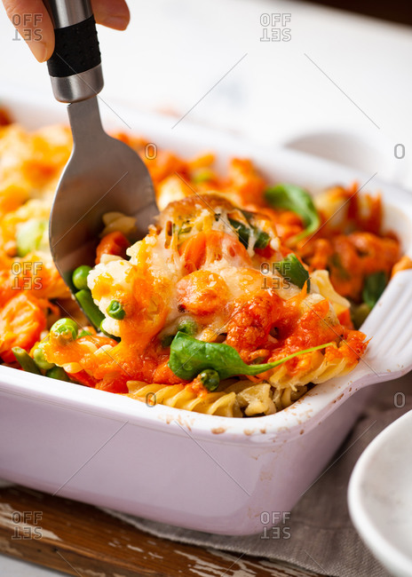 Baked macaroni and cheese casserole dish with vegetables