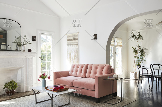February 16, 2020: Pink loveseat sofa in a living room with arched doorway