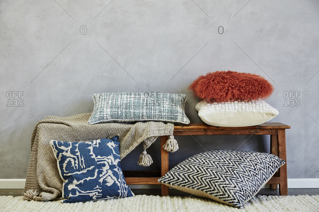 Pillows and blanket on a wooden bench