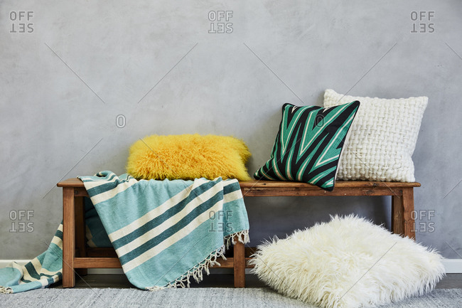 Colorful pillows and blanket on a wooden bench