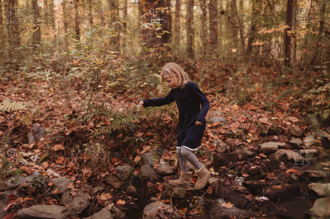 Little blonde girl exploring in the forest
