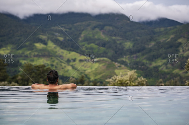 Man relaxing in swimming pool on the central highlands in Sri Lanka