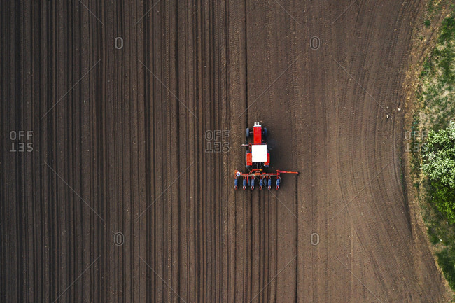 Top view of a tractor planting corn seeds in a field, high angle view