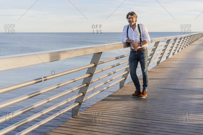 Man leaning on railing on a jetty