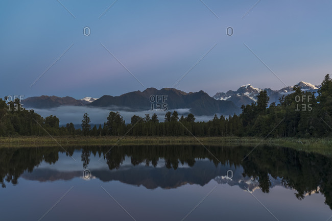 New Zealand- Westland District- Fox Glacier- Mountain range reflecting in Lake Matheson at dawn