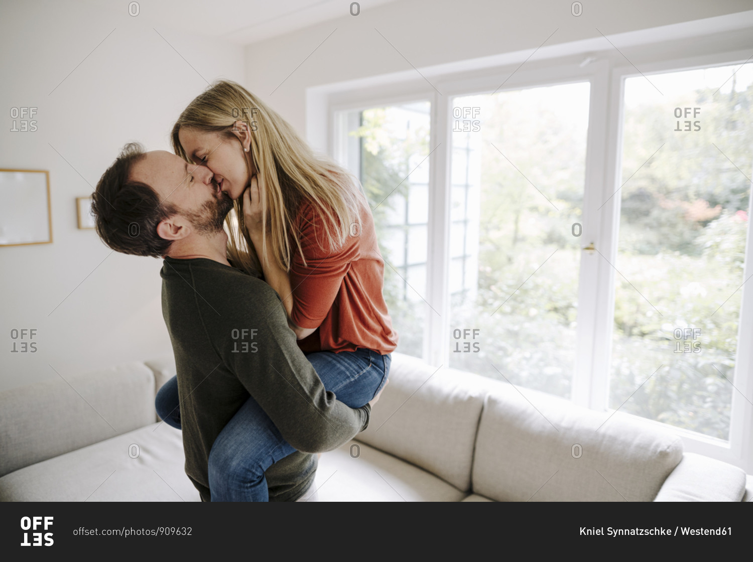 Man lifting and kissing his wife stock photo - OFFSET