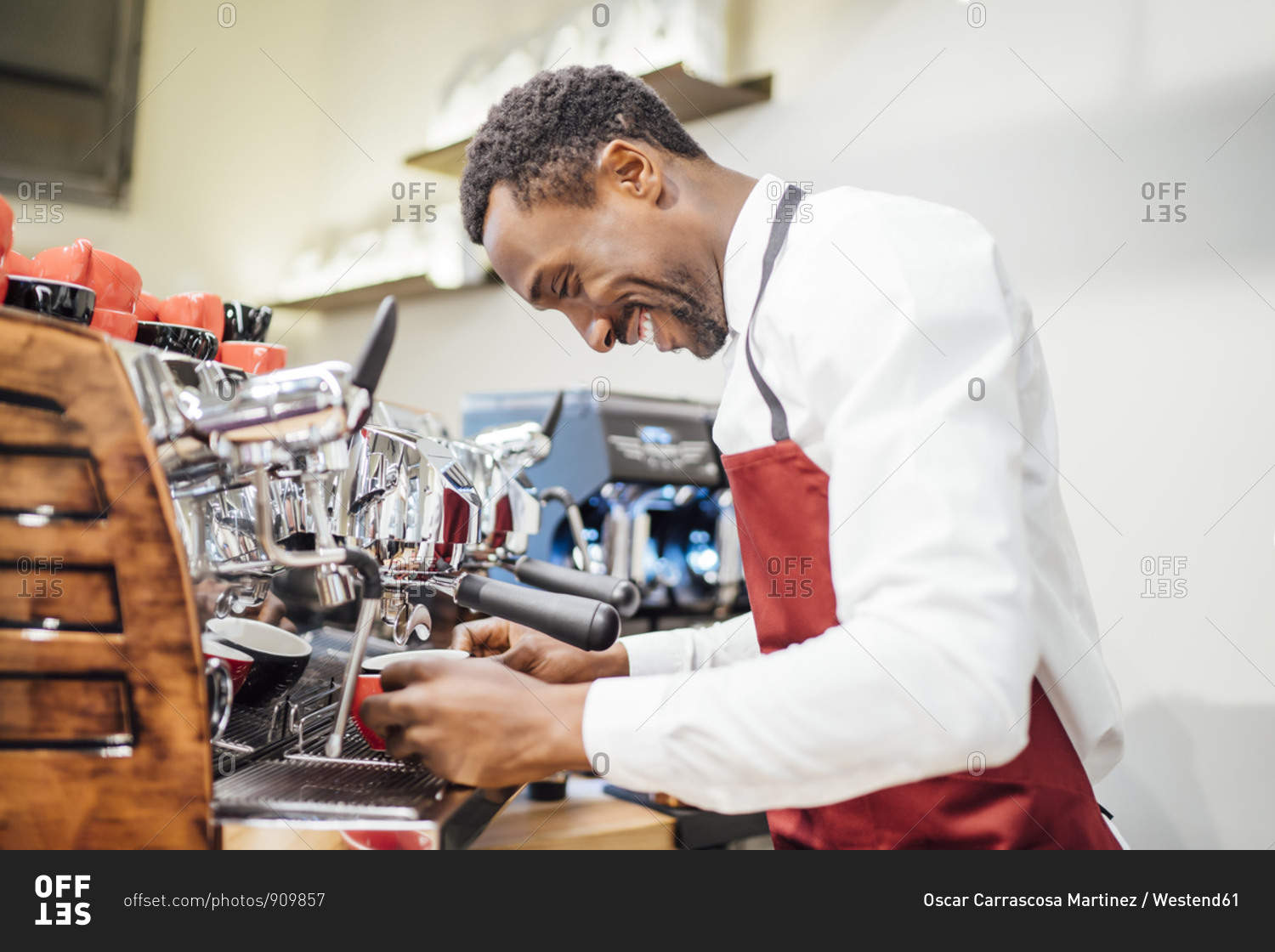 Smiling barista preparing a coffee in a coffee shop stock
photo - OFFSET