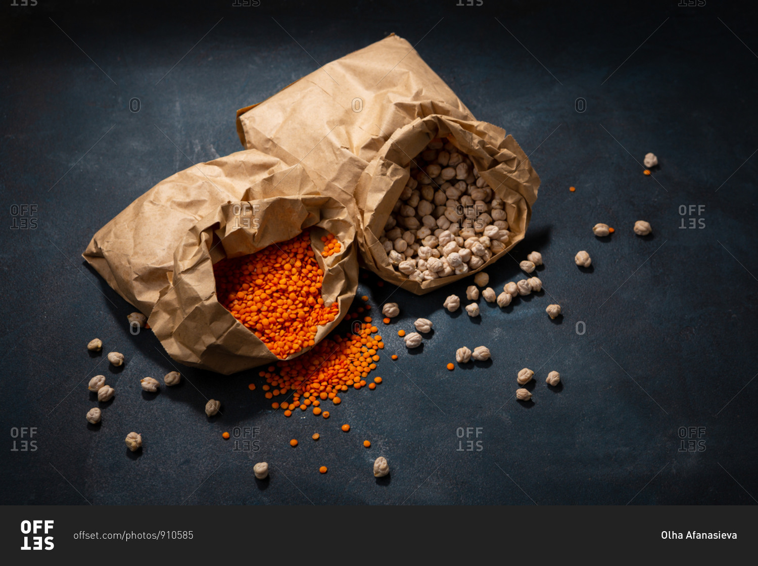 Chickpeas and red lentils in paper bags  on dark surface