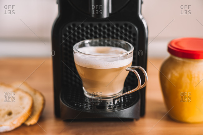Fresh latte coffee with milk on coffee machine equipment at modern kitchen