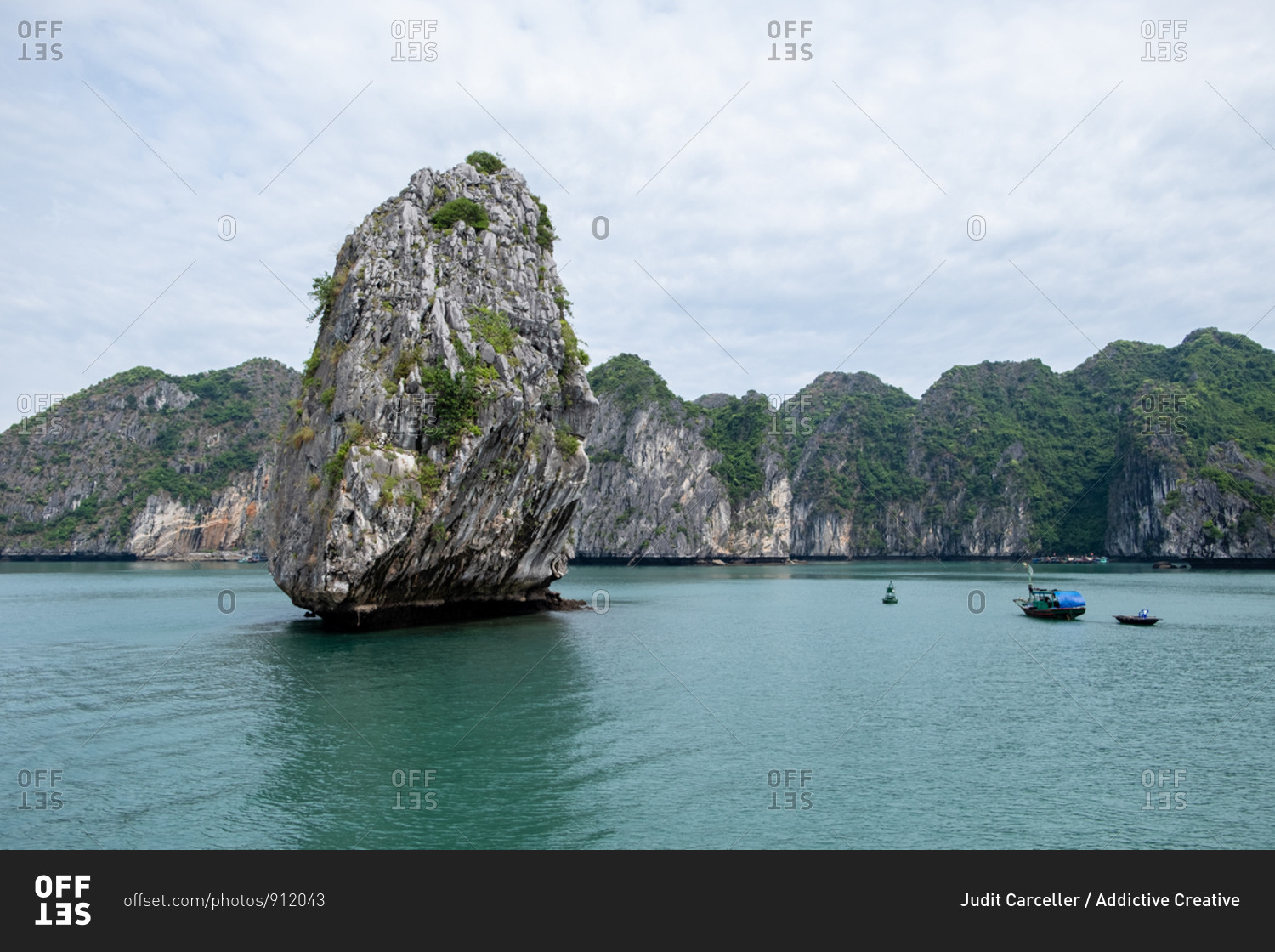 Magic scenery of solitude rock and boats in middle of Halong Bay in Vietnam