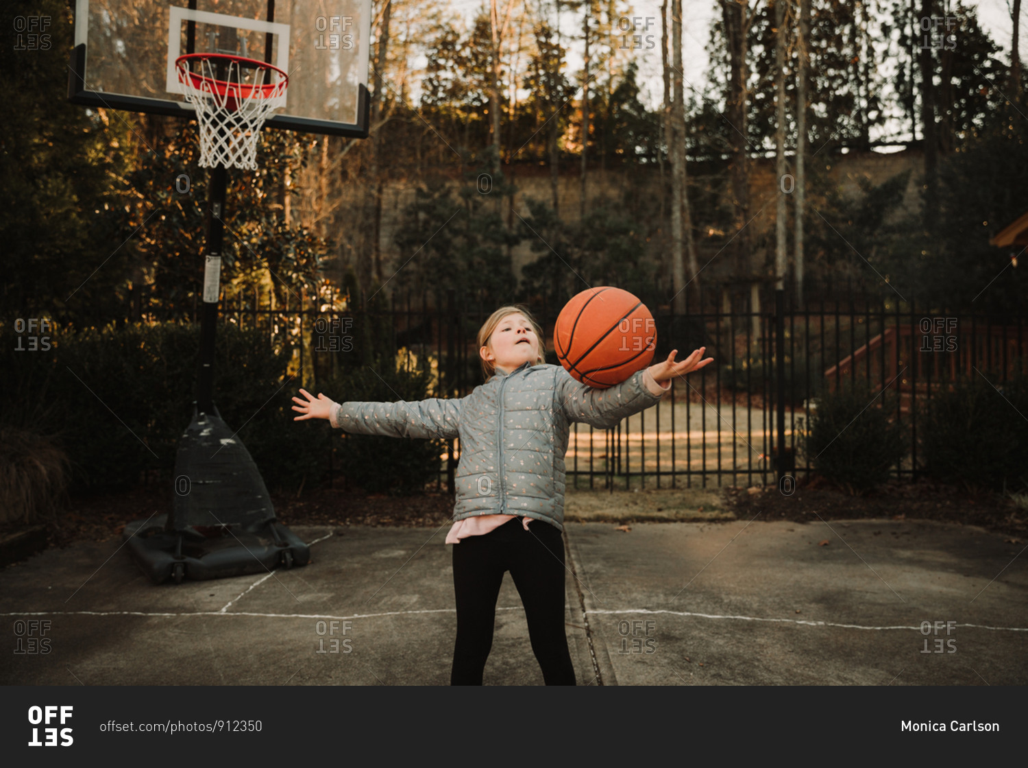 Girl playing basketball in her driveway stock photo -\
OFFSET