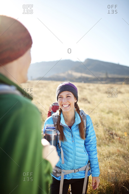 Female backpacker with water bottle laughing with male backpacker
