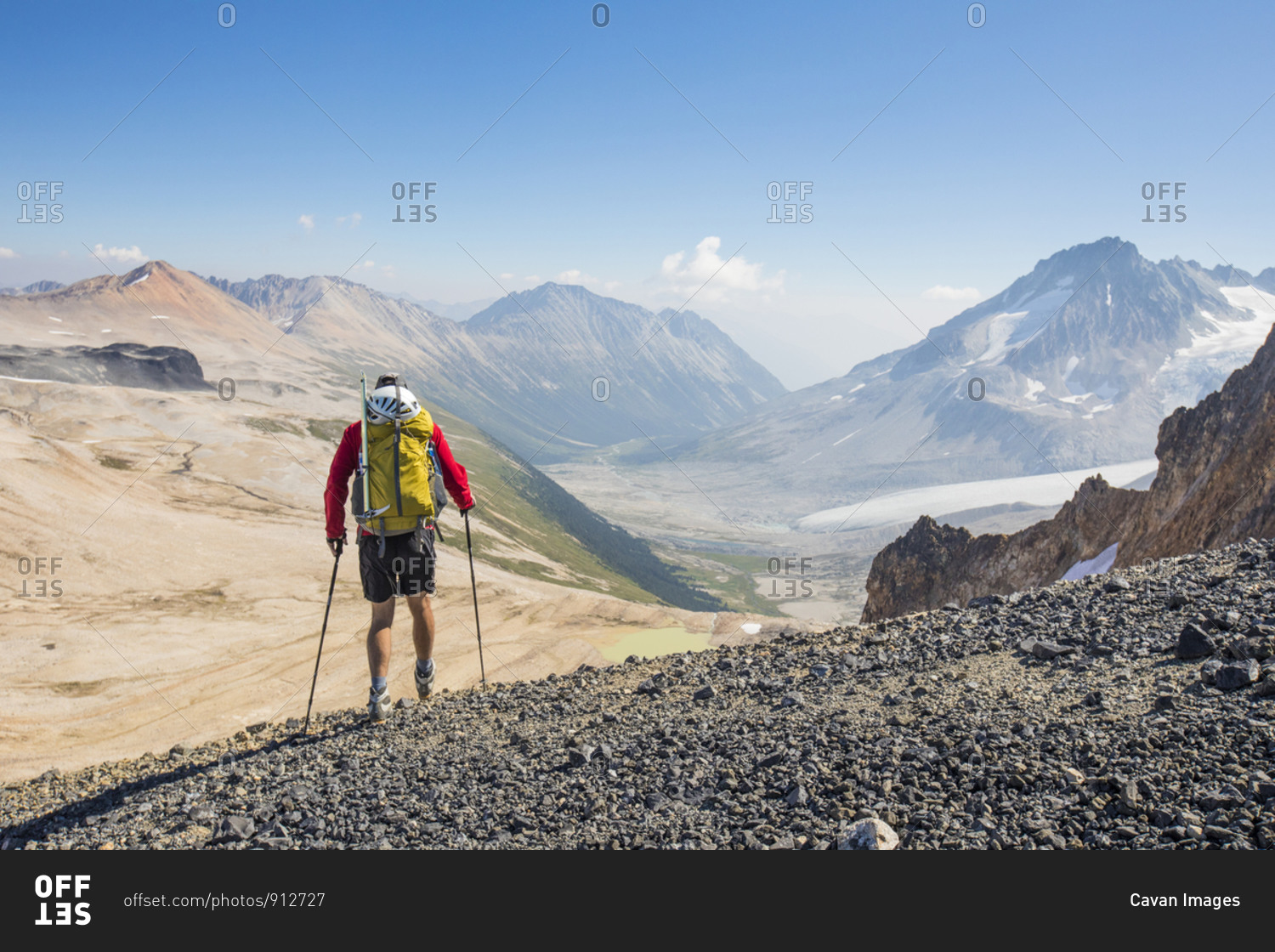 Rear view of male backpacker in high mountains.