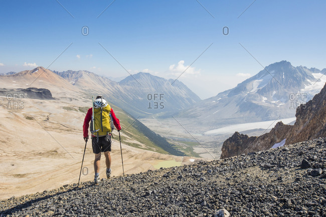 Rear view of male backpacker in high mountains.