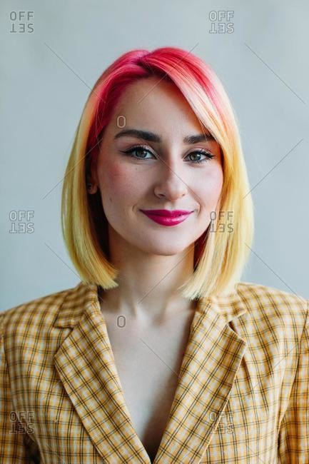 Portrait of a cool girl with dyed hair wearing a suit