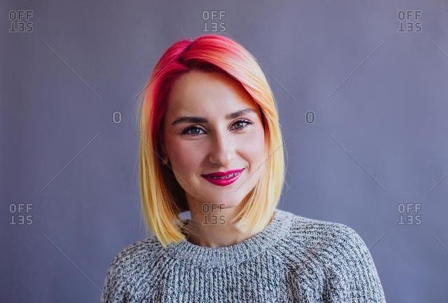 Portrait of a cool girl with dyed hair sitting on a chair