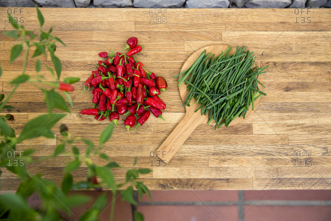 Chili peppers and chive on wooden worktop