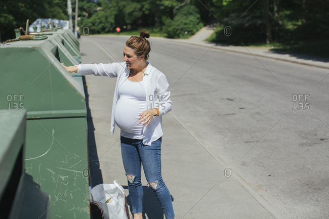 Pregnant woman sorting her recycling
