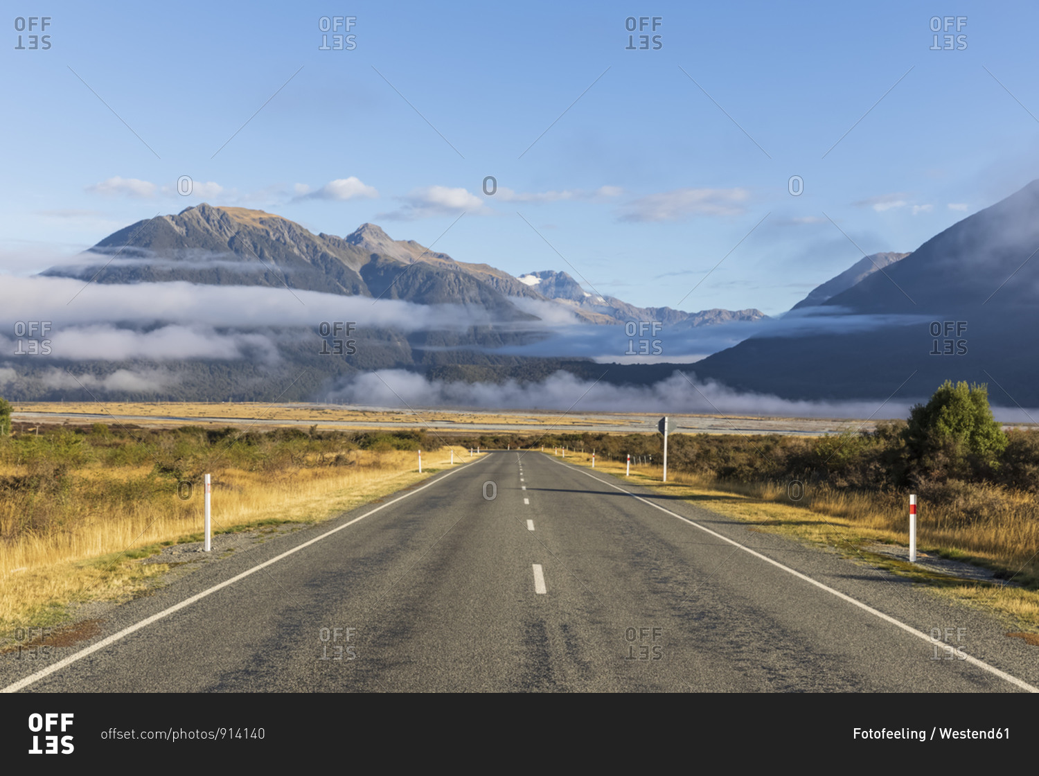New Zealand- Fog floating over empty State Highway 73 with mountains in background