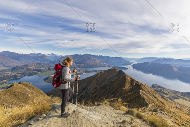Woman standing on viewpoint at Roys Peak- looking to Mount Aspiring- Lake Wanaka- South Island- New Zealand