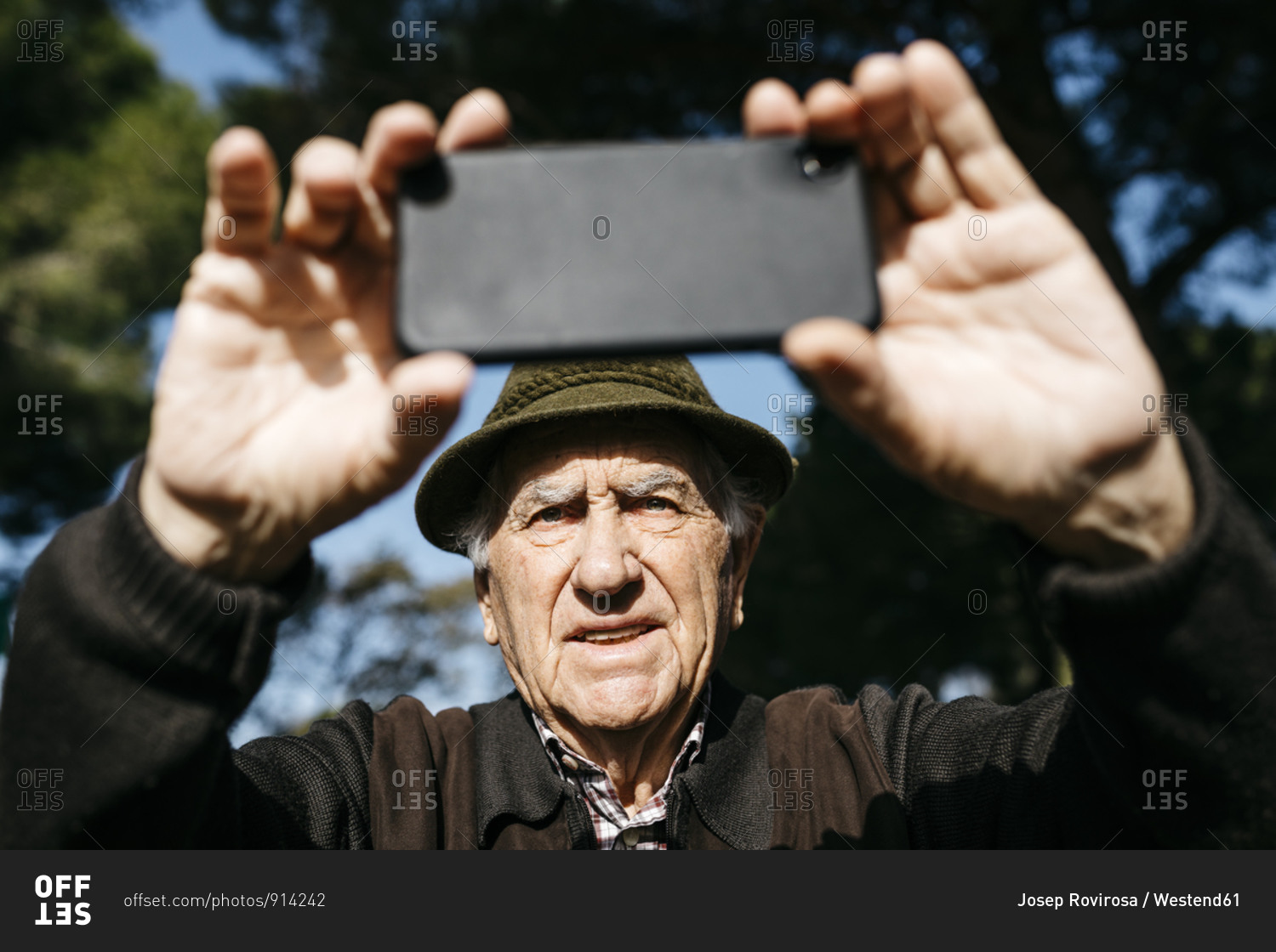 Old man taking pictures with his smartphone