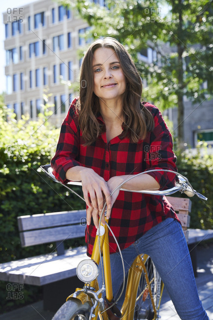 Portrait of brunette woman with bicycle in the city