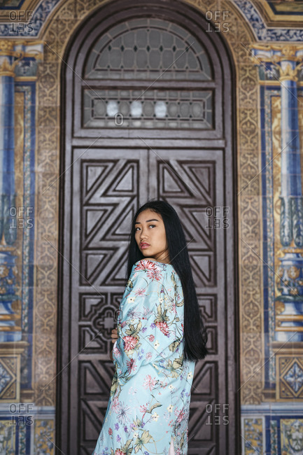 Portrait of beautiful young woman wearing a kimono in front of a door