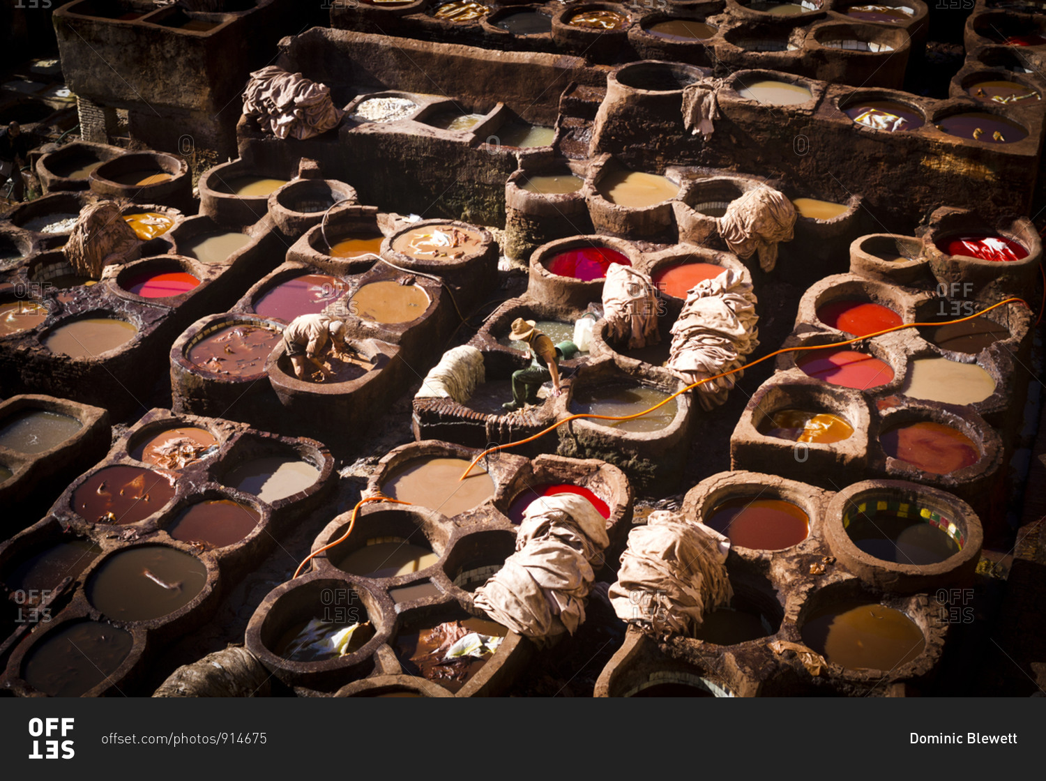 Workers tanning leather in pots of dye in the Tanners Quarter of Fes, Morocco