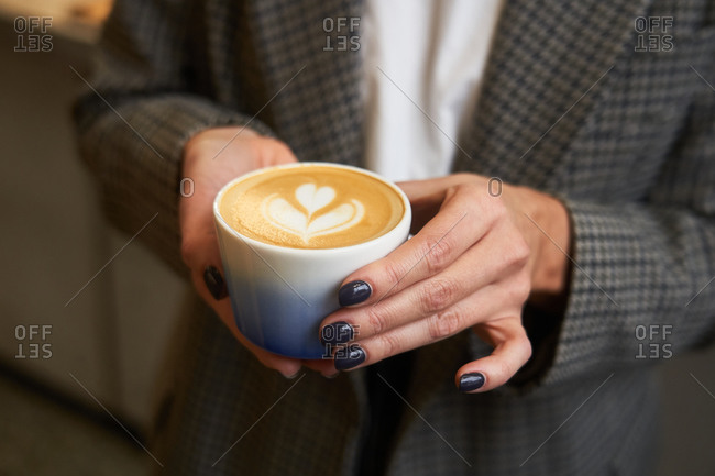 Woman holding a latte - Offset