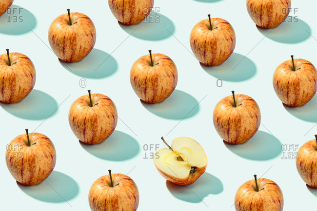 Pattern background of red apples on cyan background. Vibrant colorful pattern