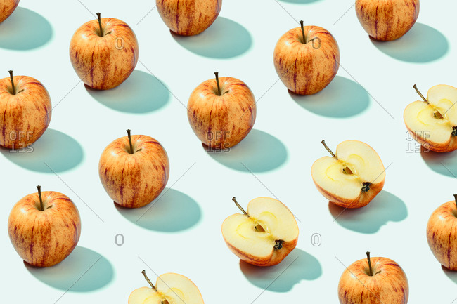 Pattern background of red apples on cyan background. Vibrant colorful pattern