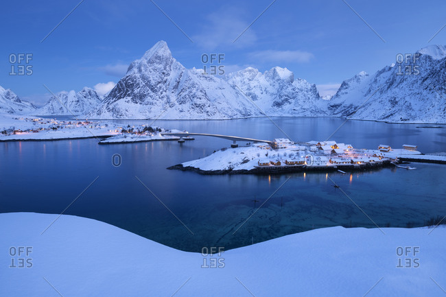 Winter twilight over Sakrisøy and Olstind mountain peak, Moskenesøy, Lofoten Islands, Norway